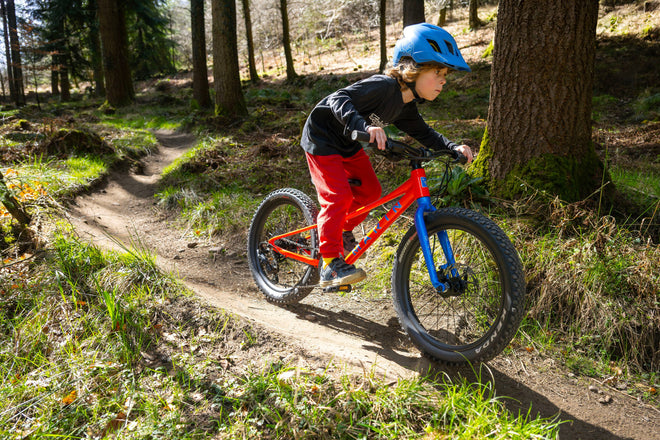 boy in bright clothes rides MTB offroad