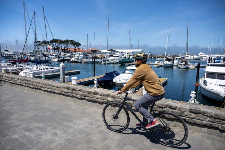 man riding a bike along the water front 