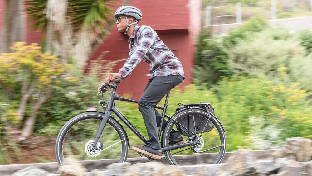 An image of a male cyclist riding a Marin Bikes flat bar bicycle down a city street