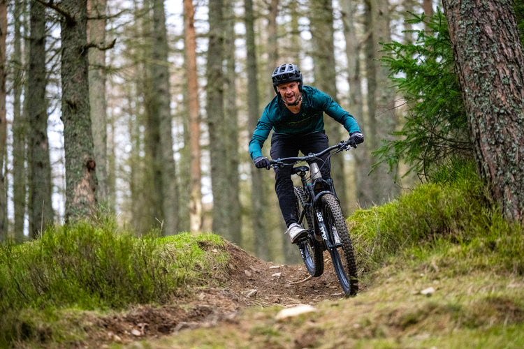 Man riding an ebike on a woodland trail