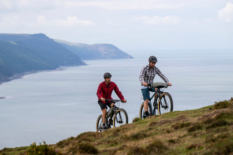 Two men bikepacking on a coastal trail