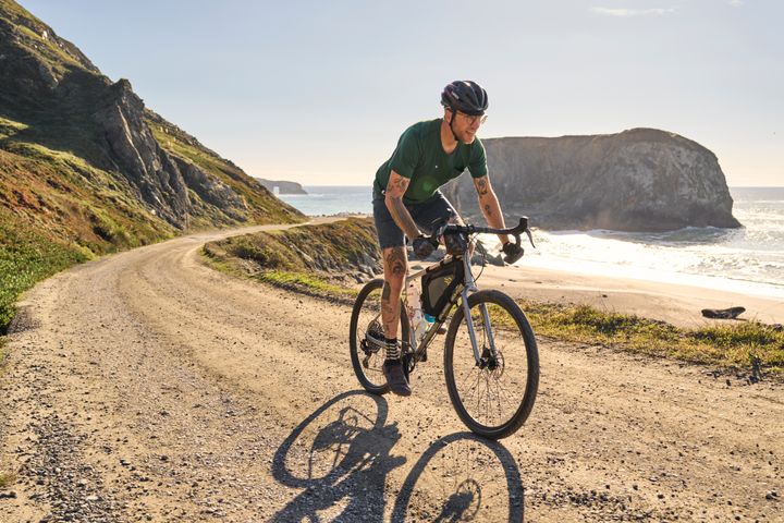 Man rides along a gravel track on the coast