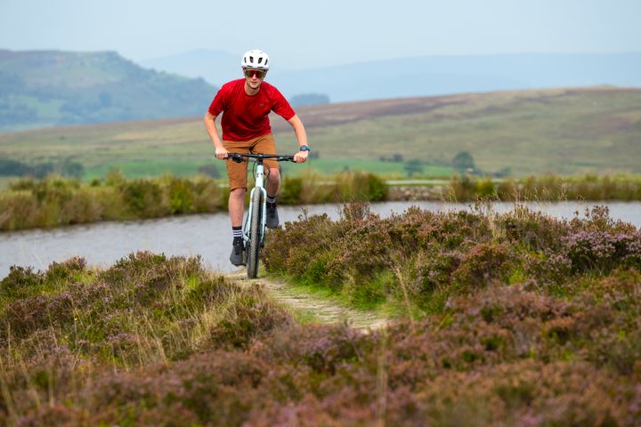 Man riding a bike next to a lake