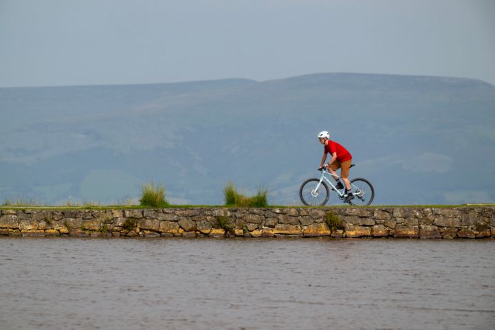 Man riding a bike next to a lake
