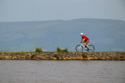 Man riding a bike next to a lake