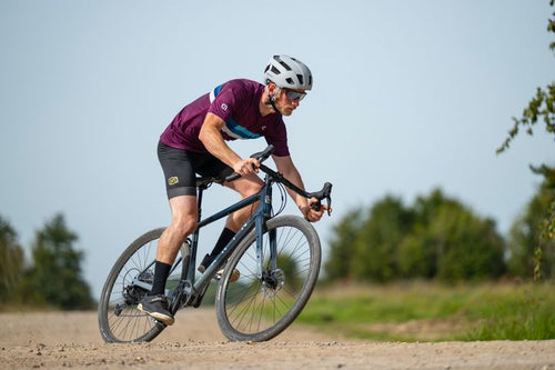 Man rides a gravel road on a dropbar bike