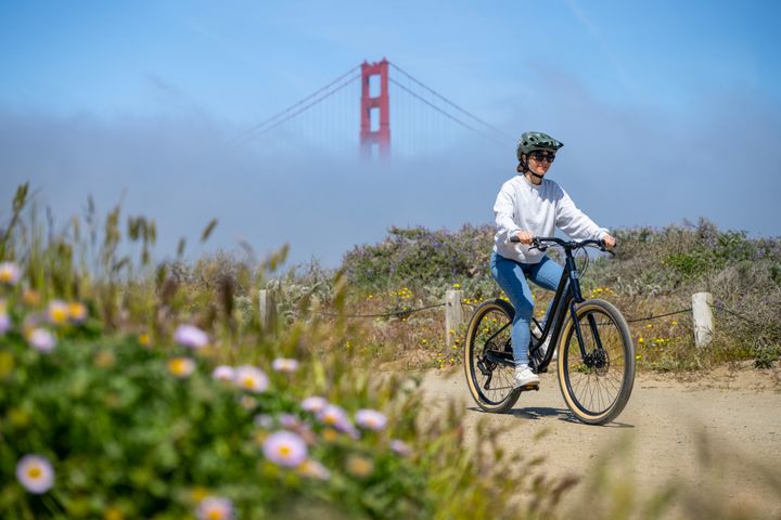 Person riding a bicycle with the Golden Gate Bridge in the background