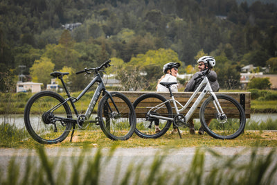 A couple sit on a bench during an ebike ride