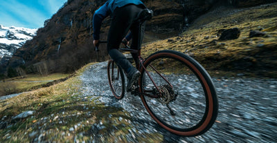 Man rides bike up gravel path
