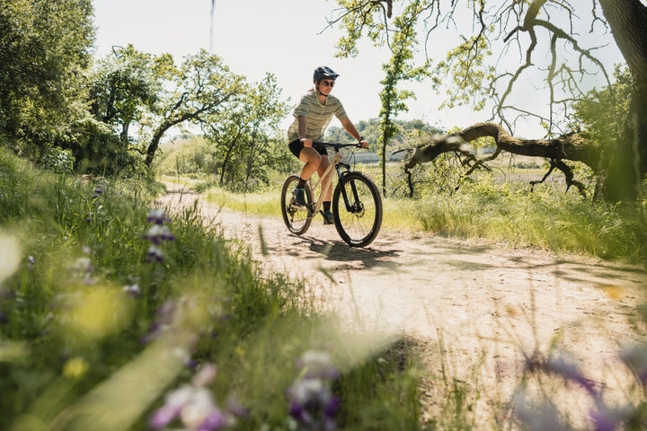 Woman rides along a flower lined trail