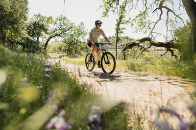 Woman rides along a flower lined trail