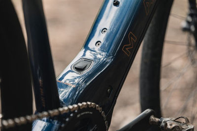 Close-up of a bicycle frame with chain and pedal, blurred background