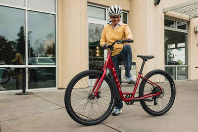 Woman gets on a bike in an urban location