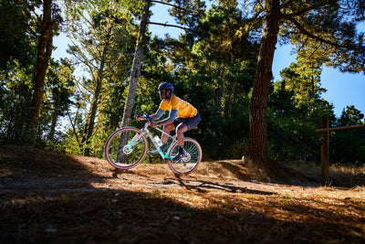 Man riding a dropbar bike on a woodland trail