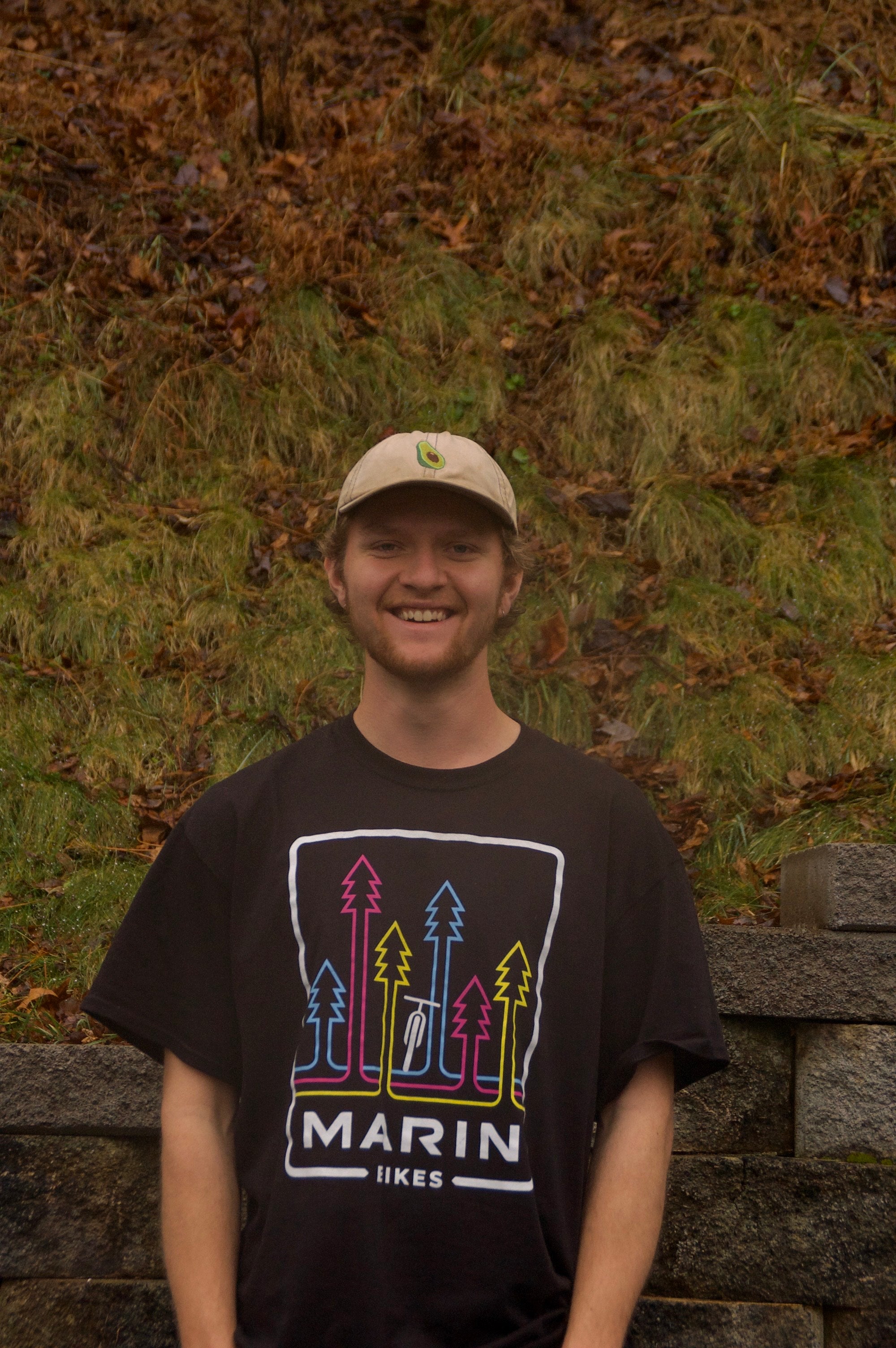 Person wearing a black t-shirt with 'Marin Likes' design against a natural background