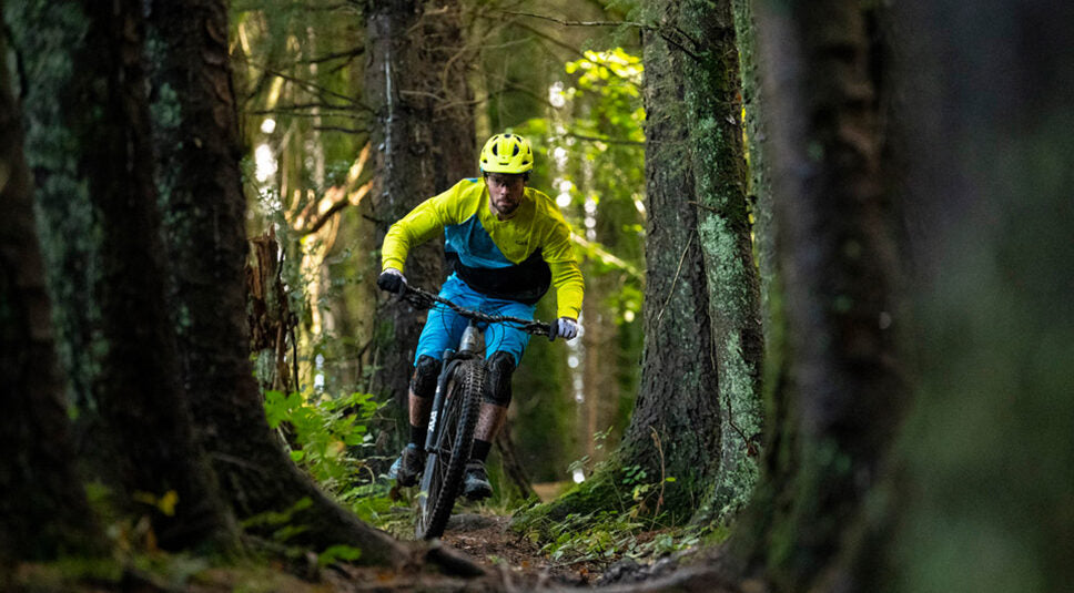 Nikki Whiles riding a Rift Zone Carbon 2 mountain bike through the trees, Wales UK.
