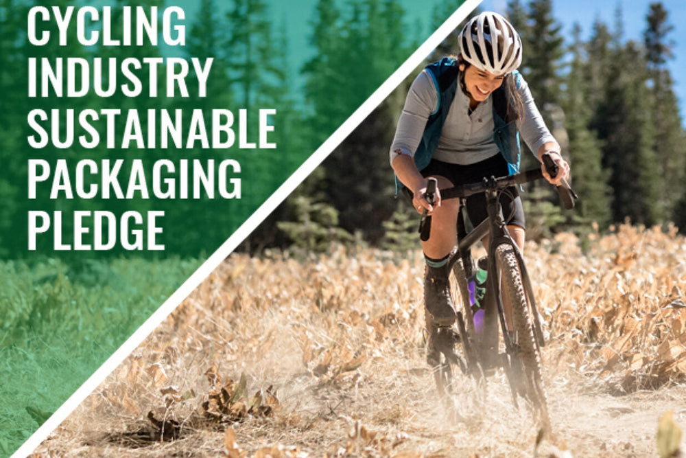 An image of a female cyclist riding a Marin Bikes drop bar gravel bike with a brown dog in the countryside with the words 'cycling industry sustainable packaging pledge' overlayed on the image
