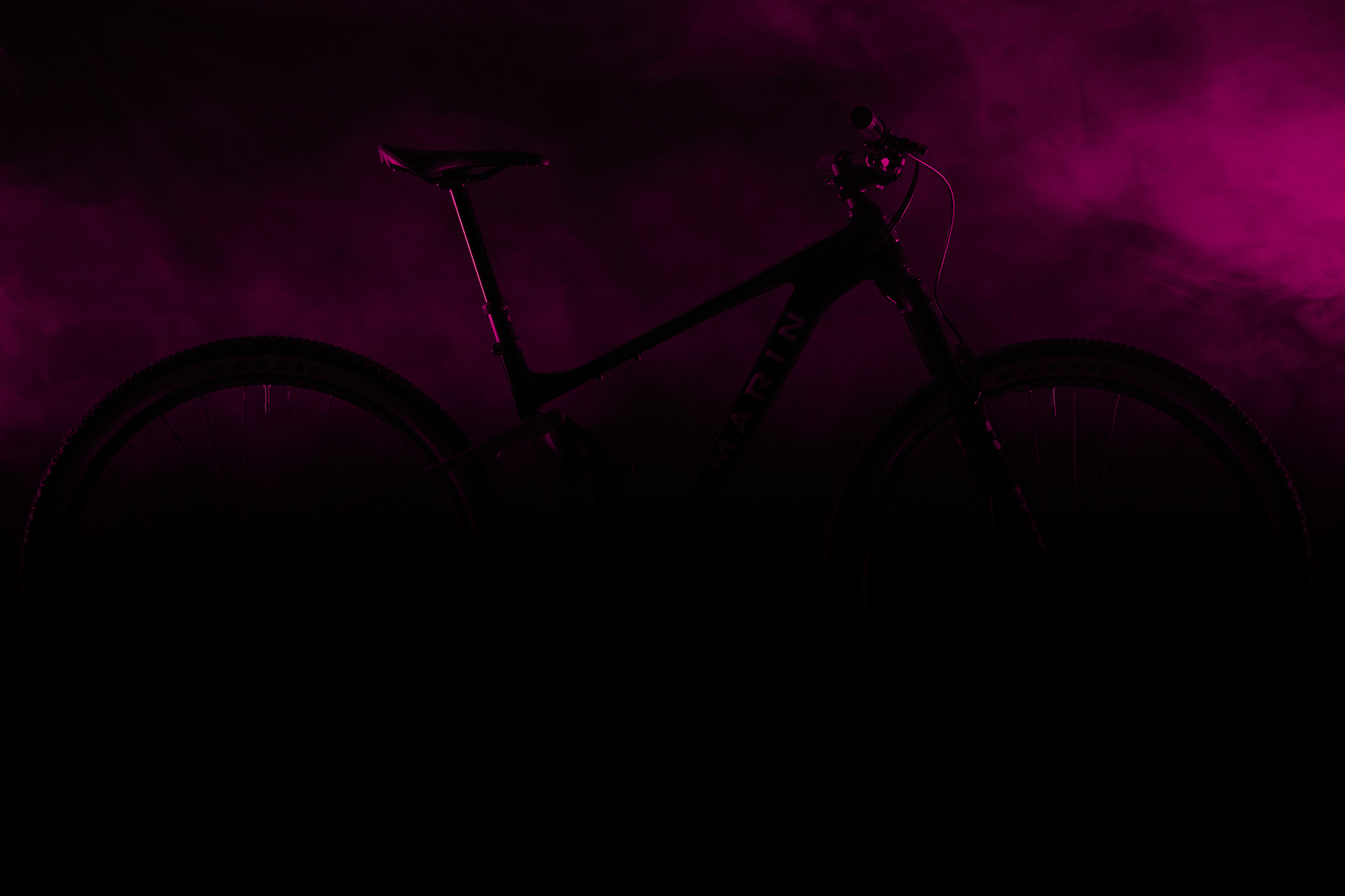 Silhouette of a bicycle against a dark purple background