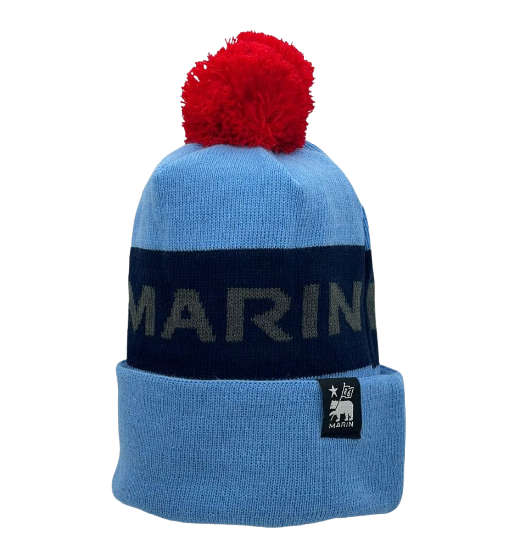 A blue and black Marin Bikes bobble hat, with a red bobble